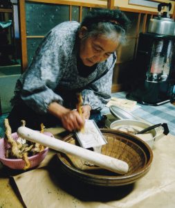 写真3-4 裏山から採ってきた自然薯でとろろ汁を作る富枝おばあさん（2001年晩秋）